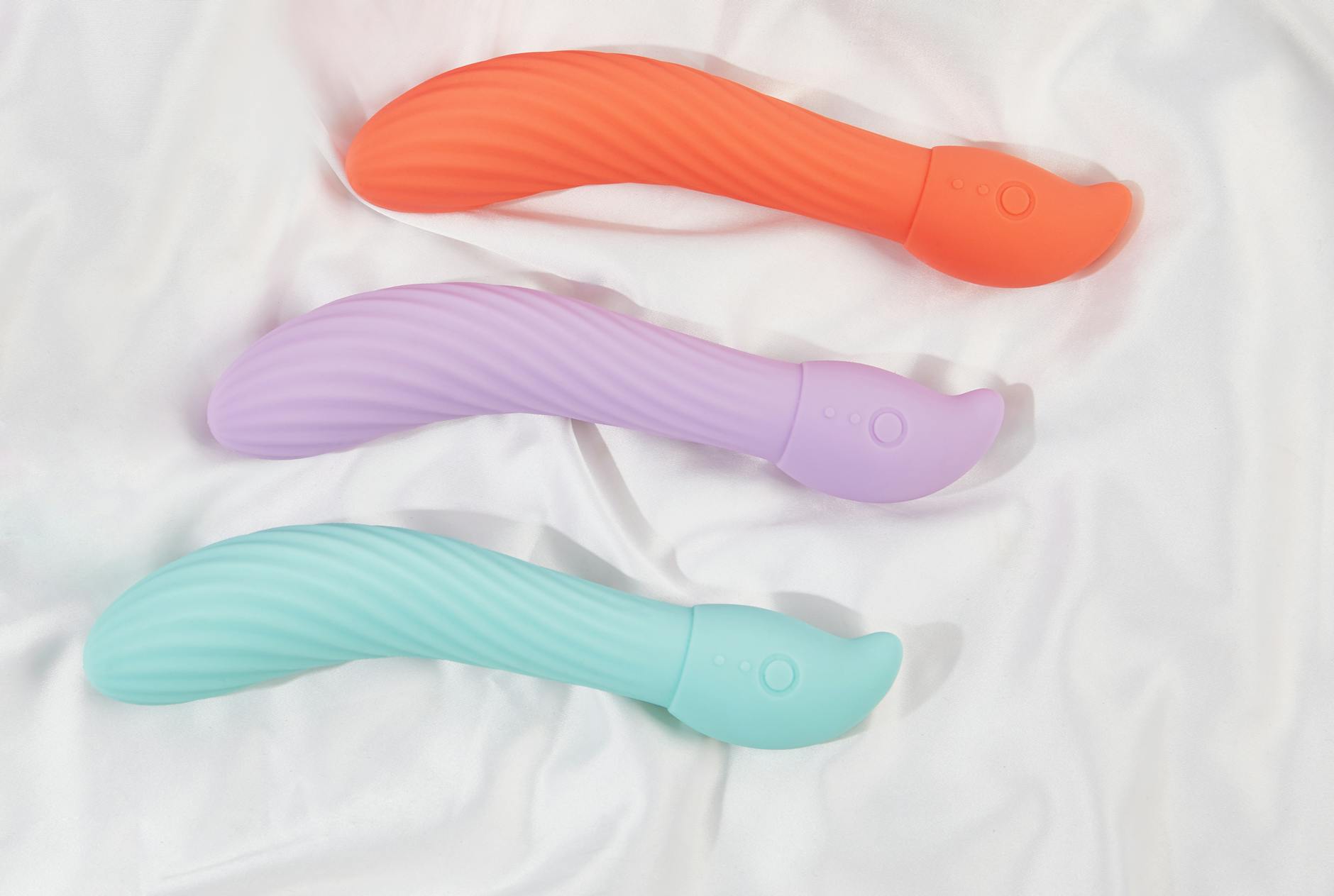 Pink vibrator on purple background with heart confetti and candles