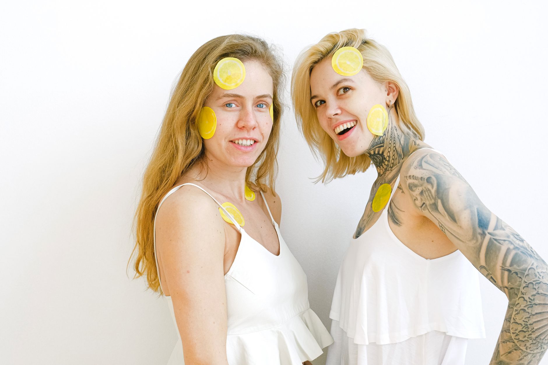 Hands holding a sleek lemon clitoral vibrator against a soft background