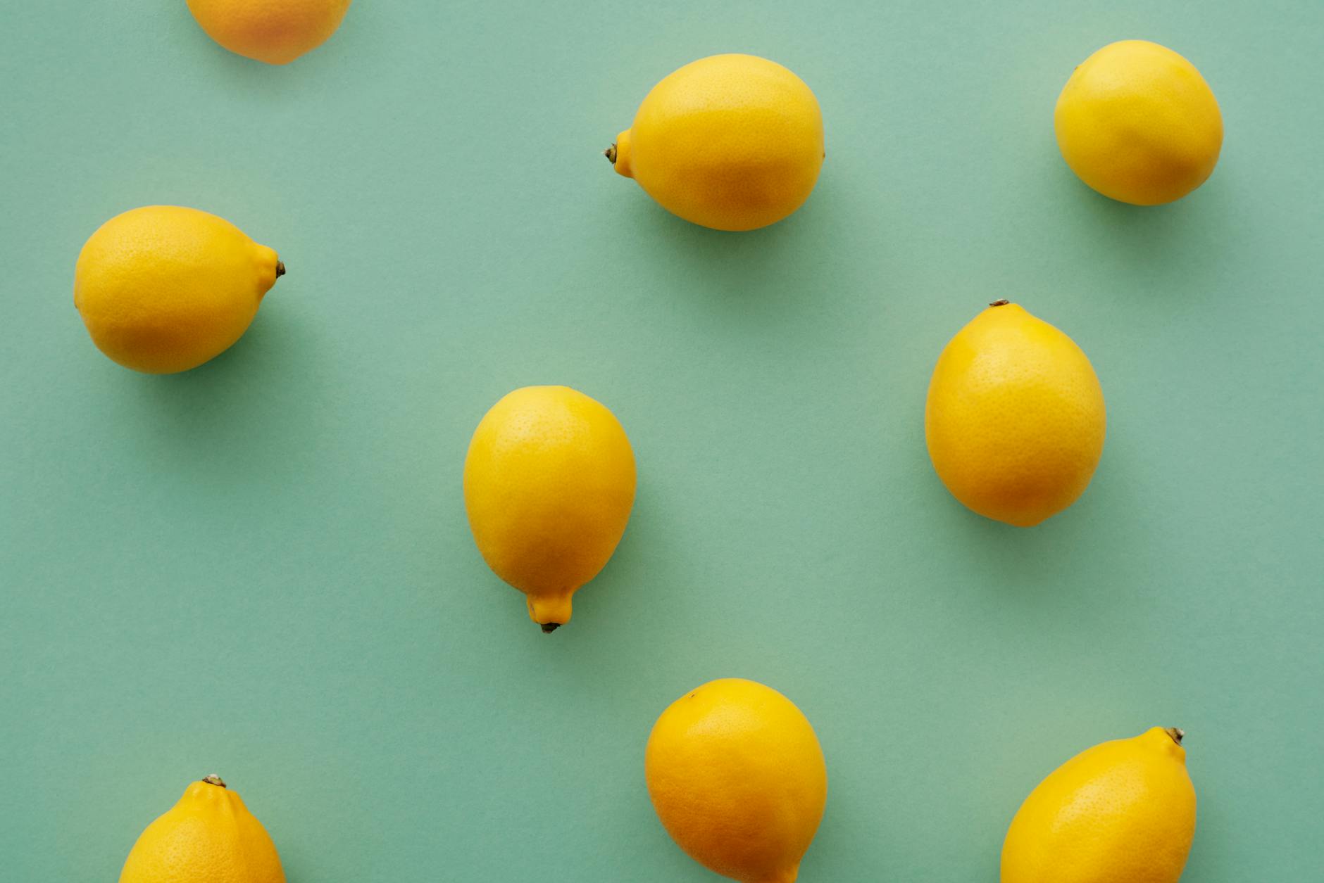 Bright yellow lemons arranged on a pastel background, symbolizing the fresh approach to pleasure during hormonal transitions.