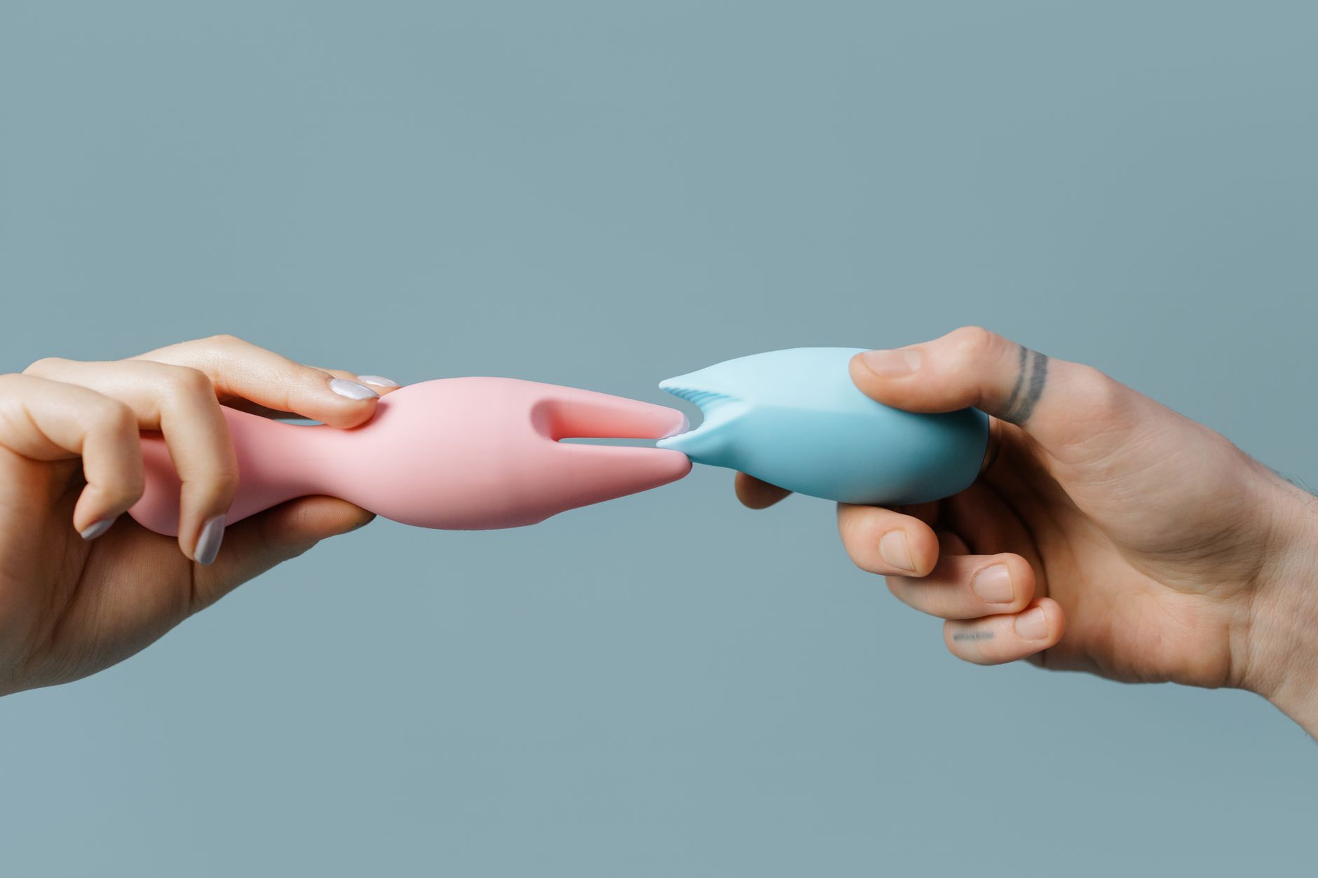 Colorful silicone vibrators arranged on a neutral surface, representing accessible pleasure tools.