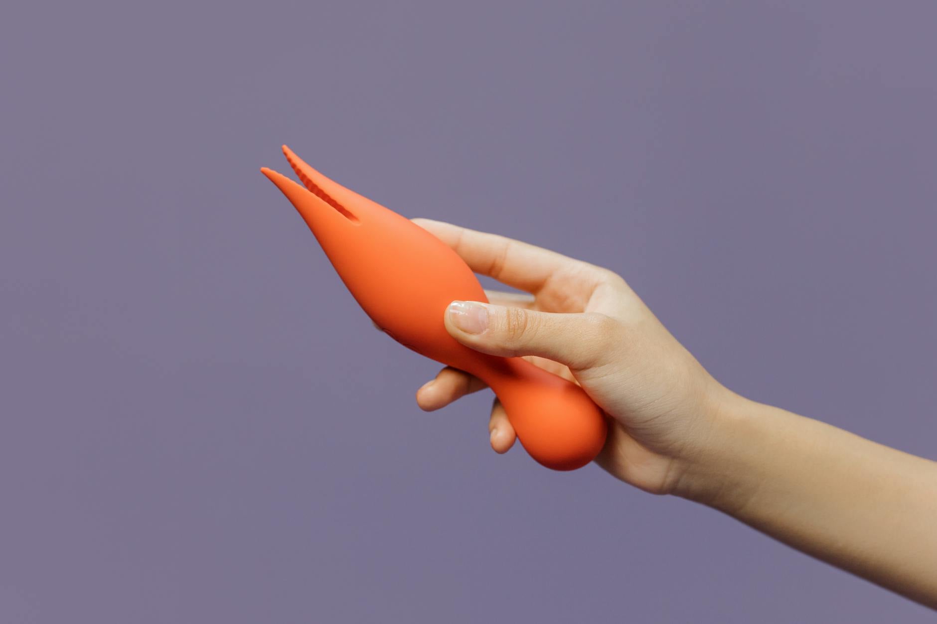 Hand holding a vibrator demonstrating sensual exploration and modern intimate wellness.