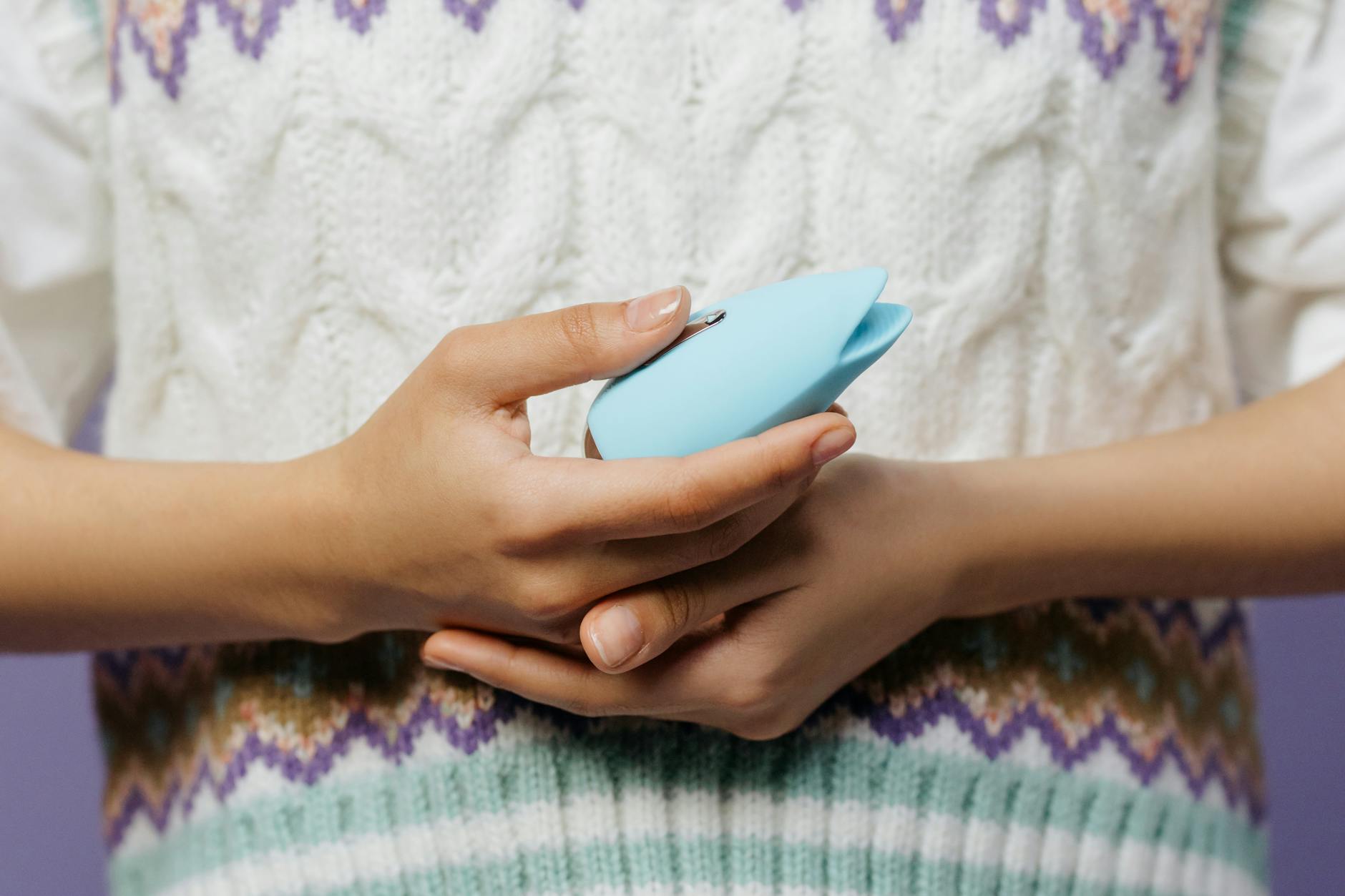 Woman holding colorful vibrators thoughtfully, representing choices for rebuilding arousal after IUD insertion.
