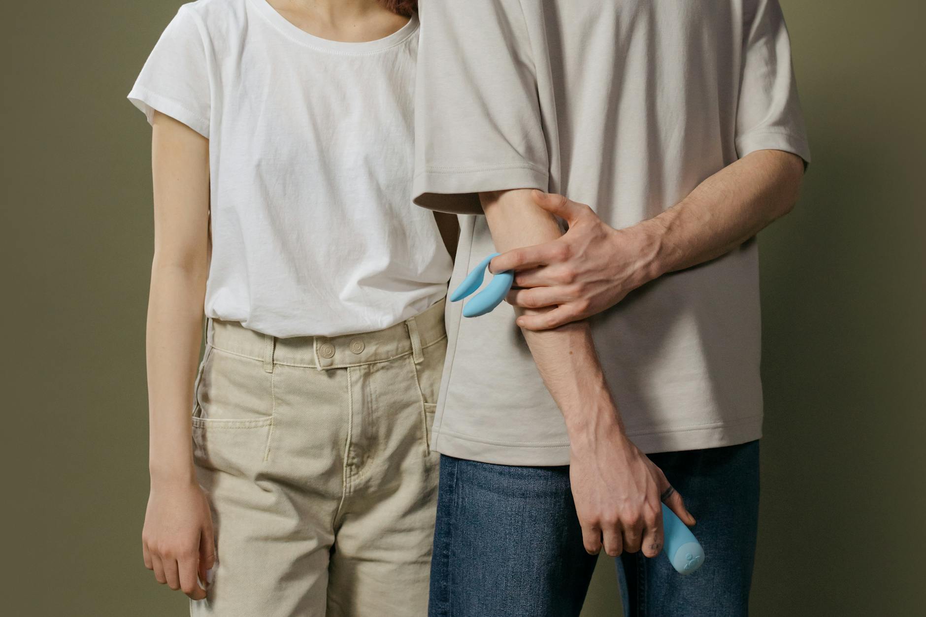A couple holding hands while relaxing together, representing intimate connection during pregnancy