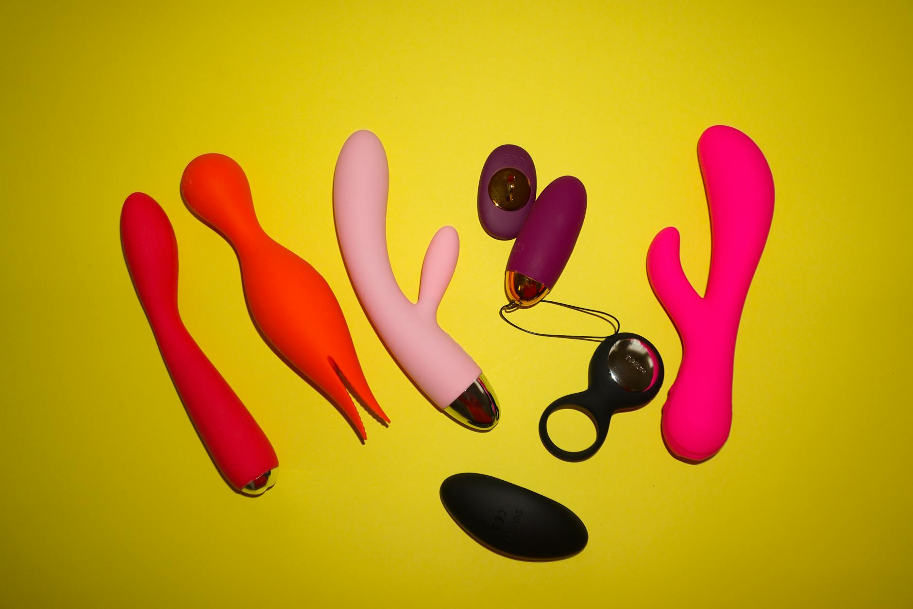 Close-up of hands holding a personal vibrator against a soft knitted sweater
